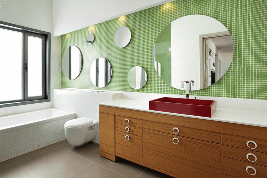 Muchos espejos redondos en el baño con iluminación cenital